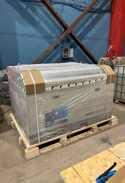 Деревянный поддон с упакованным промышленным оборудованием, фиксация стреп-лентой